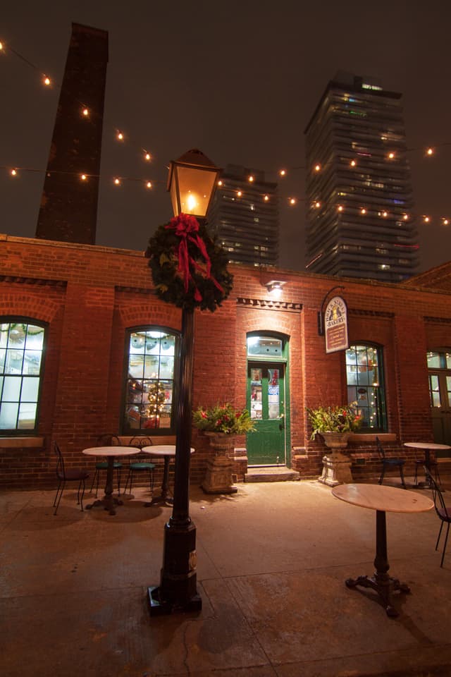 Gas street lamps illuminate the streets, in sharp contrast to the condos rising stories above.