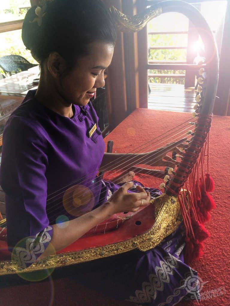 Burmese woman playing arched harp in Bagan