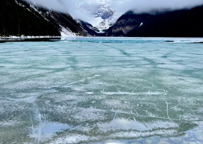 Lake Louise semi frozen with pebbles in shore Banff