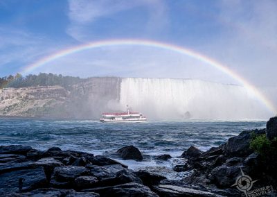 Tour boat approaching Horseshoe Falls under double rainbow