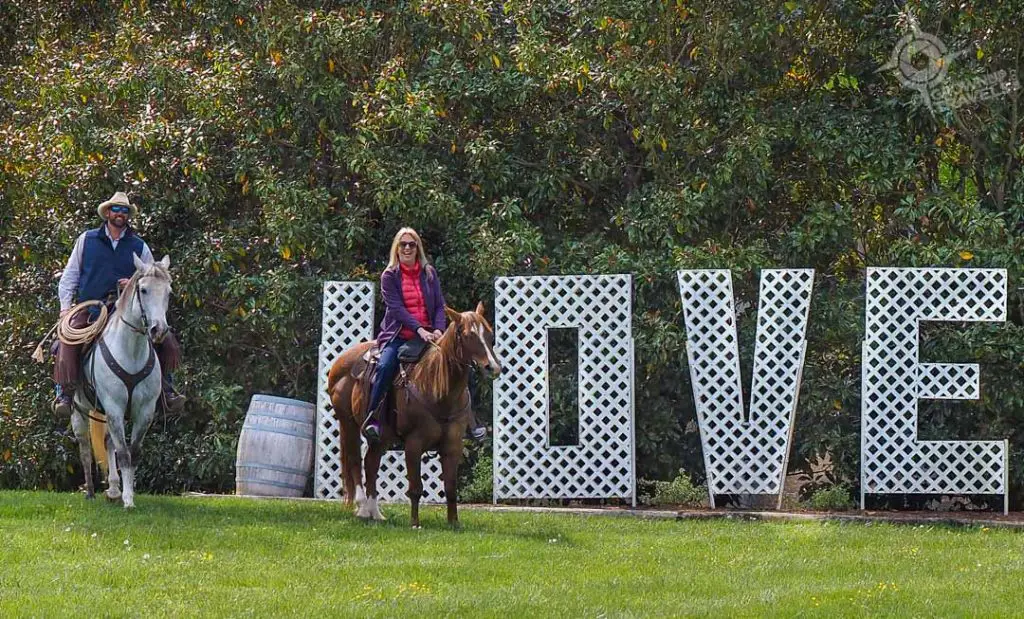 Jane and Ashton with horses at Love sign