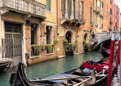 Gondola parked on colourful canal Venice