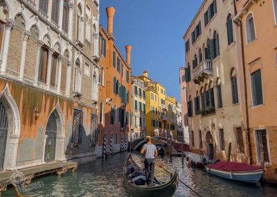 Gondolier on colourful canal Venice