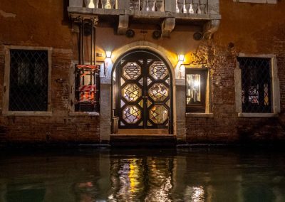 Venetian home with glass doors on canal at night-2