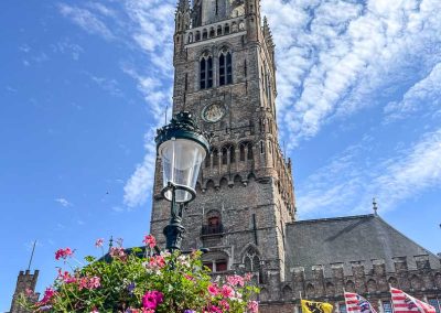 Lamp post with flowers and Belfry Bruges Belgium