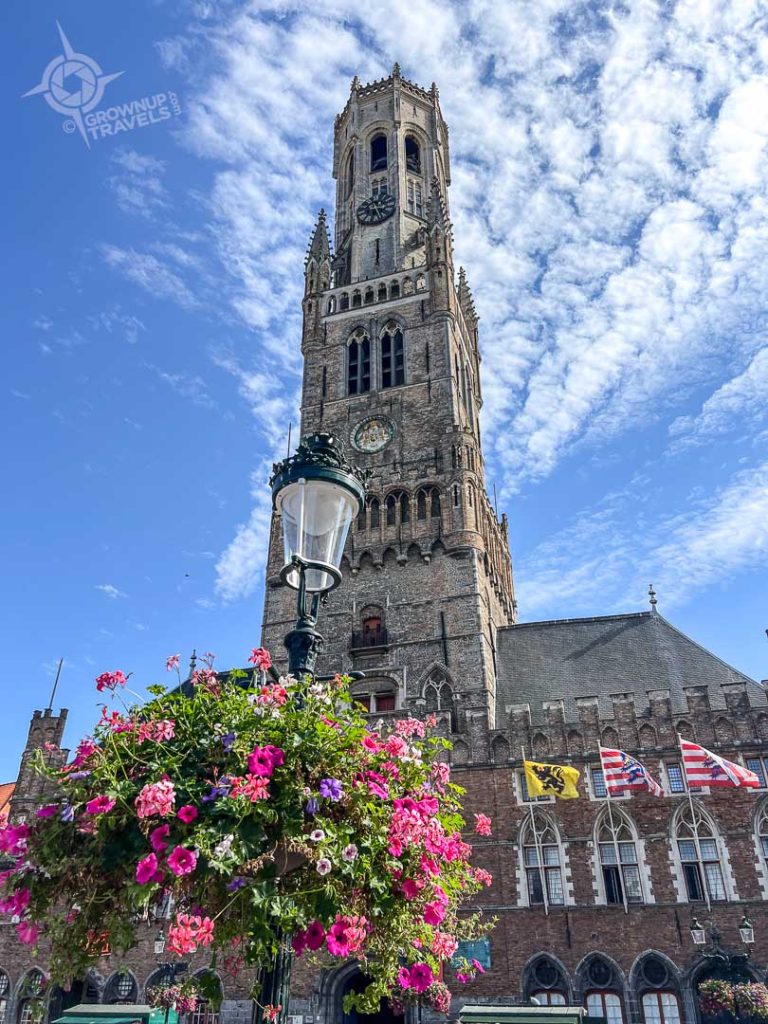 Lamp post with flowers and Belfry Bruges Belgium