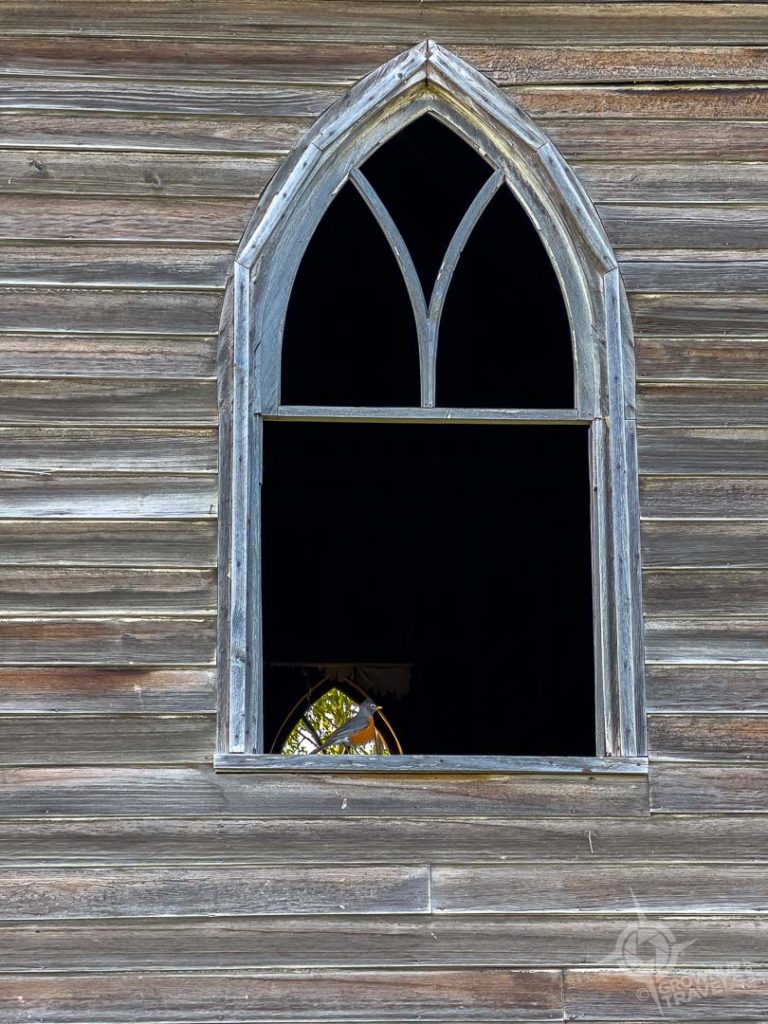 Unfinished wooden Ukrainian orthodox church with robin in window